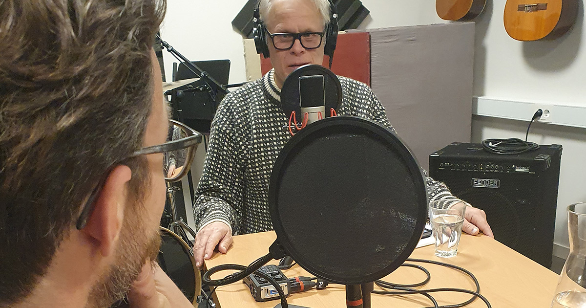 Två män sitter vid varsin mikrofon