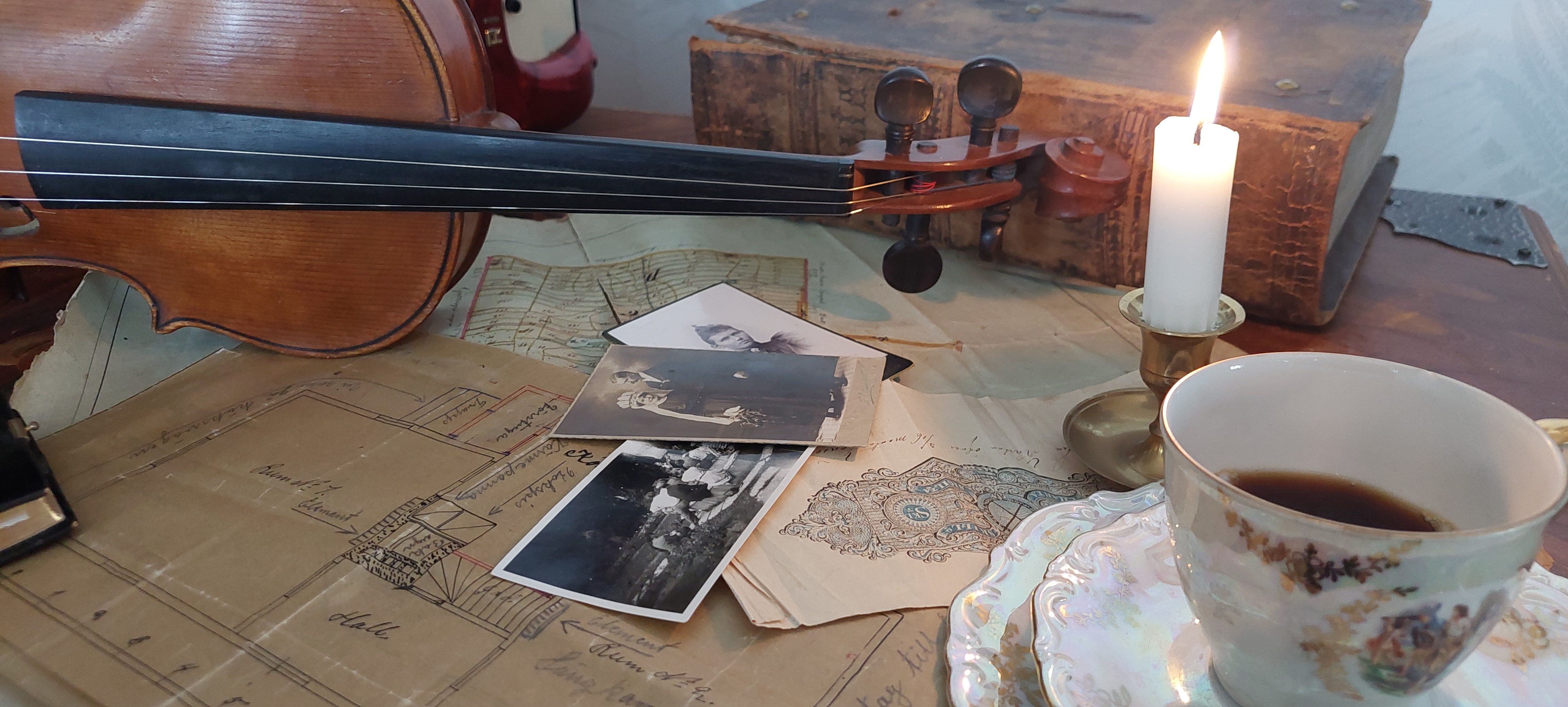 Fiol, gamla bilder, en kopp kaffe och en gammal bok